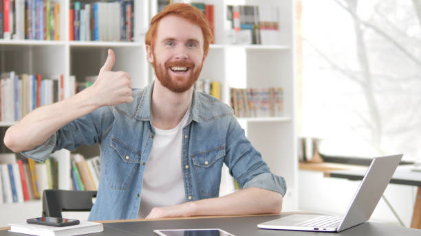 istock Thumbs Up by Young Casual Redhead Man at Work 1296274819