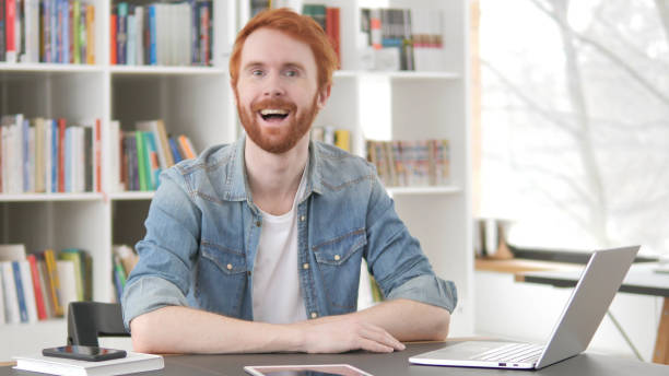 istock Talking Excited Young Redhead Man in Office 1296274824