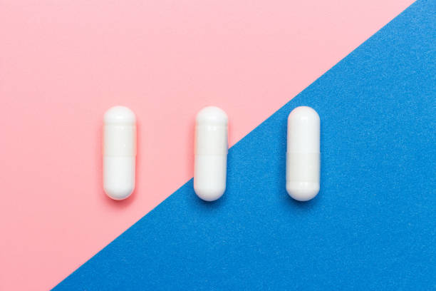 istock White collagen capsules on pink and blue background, copy space 1296275129