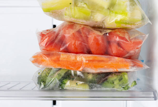 Frozen vegetables in plastic bags in freezer close-up, front view Frozen vegetables in plastic bags in the freezer close-up, front view deep pick stock pictures, royalty-free photos & images
