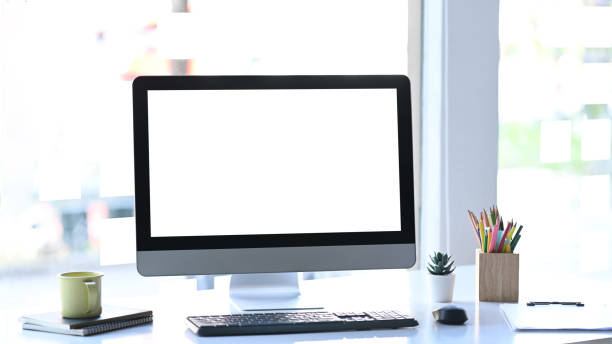 istock Stylish workstation with computer, coffee cup and office supplies on white table. 1296276144