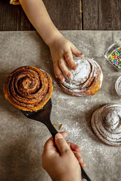 istock Children's hand takes a freshly baked cinnamon bun 1296276188