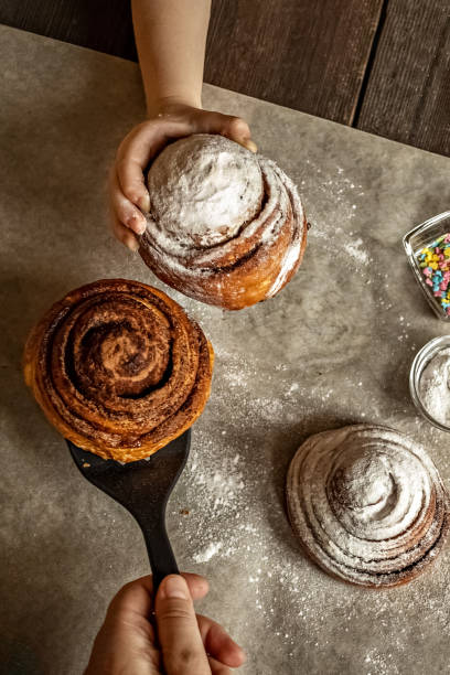 istock Children's hand takes a freshly baked cinnamon bun 1296276200