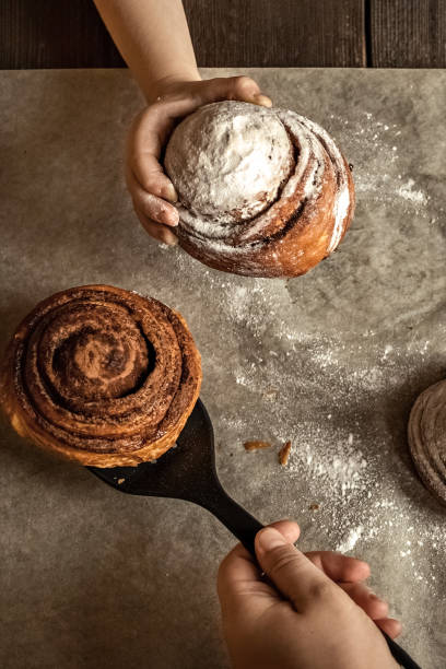 istock Children's hand takes a freshly baked cinnamon bun 1296276212