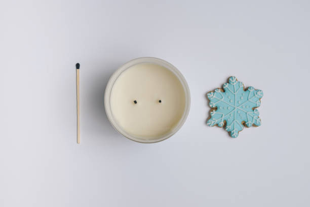 istock Winter arrangement made with blue snowflake cookie, matches and candle. Minimal flat lay on white background. 1296277095