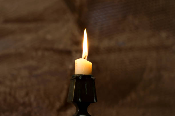 istock A burning candle in a dark room. 1296277290
