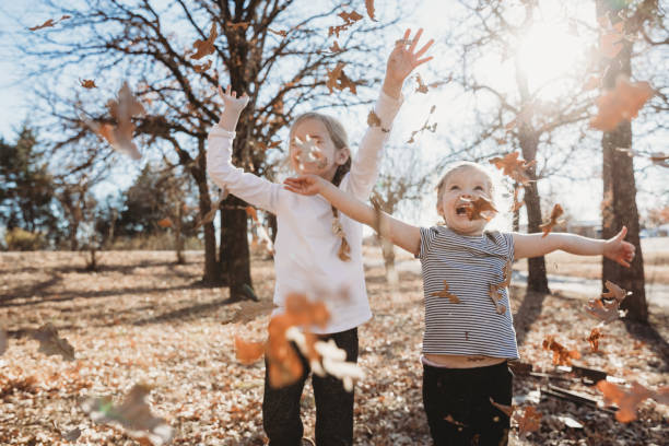 crianças gostam de brincar em pilha de folhas ao ar livre em lindo dia de outono - 3 6 months - fotografias e filmes do acervo