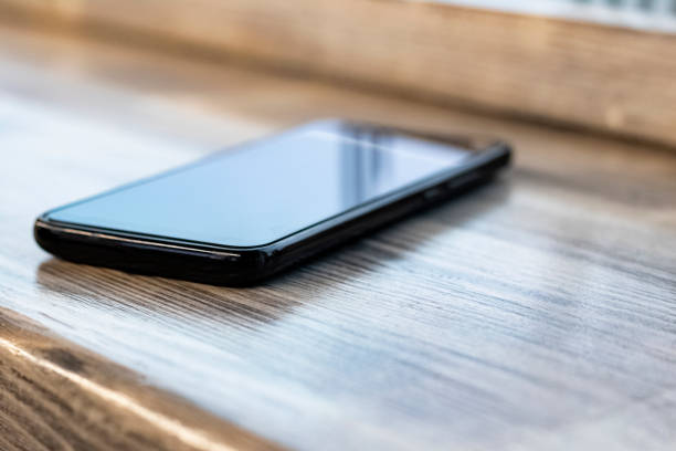 istock Mobile phone on a wooden table closeup 1296279283
