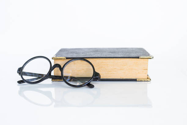 istock Reading glasses with old book on white background 1296281399