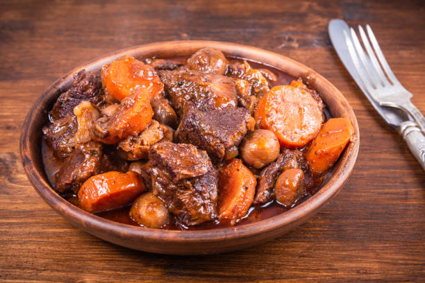 istock Ready burgundy beef in a clay bowl on a wooden table close up 1296283585