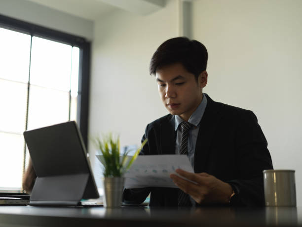 istock Businessman analysing business paperwork in office room 1296287244