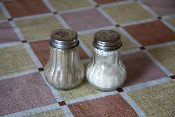 Solt and paper shakers on a table, isolated Solt and paper shakers on the table, isolated salt pepper ingredient black peppercorn stock pictures, royalty-free photos & images