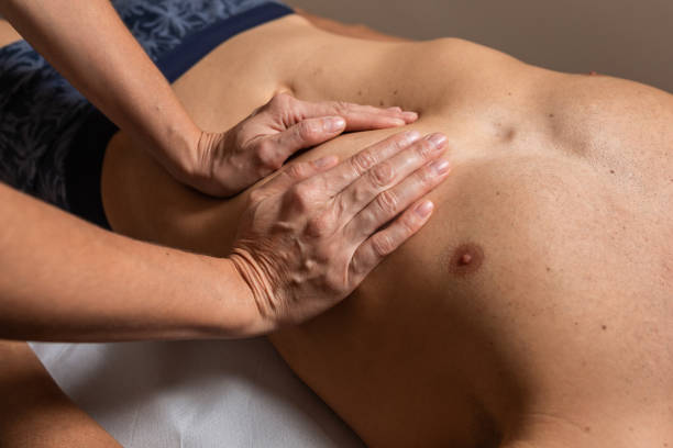 istock Woman physiotherapist does session to man. visceral ostropathy 1296290425