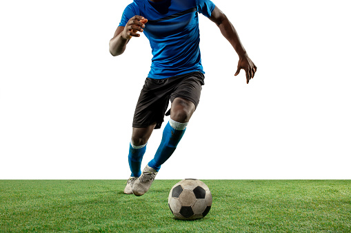 Close up legs of professional soccer, football player fighting for ball on field isolated on white background. Concept of action, motion, high tensioned emotion during game. Cropped image.