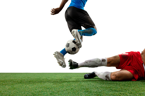 Soccer, game and man kicking a ball during training with the team on a field for sports. Athlete football player in the air to jump for a goal while playing in a professional match or competition