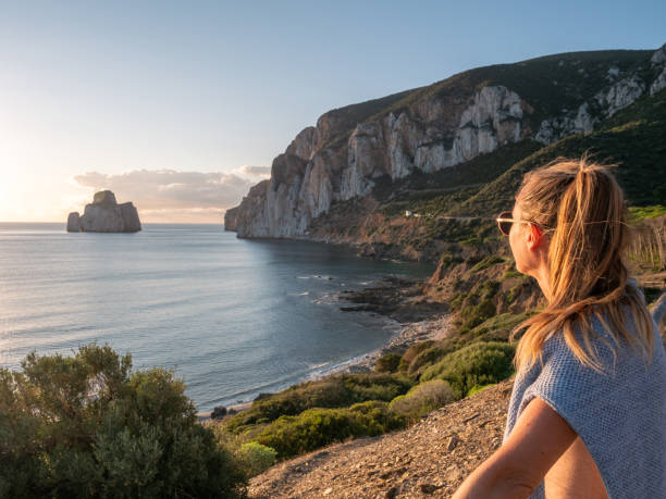 istock Woman contemplates beautiful sunset, Sardinia 1296292146