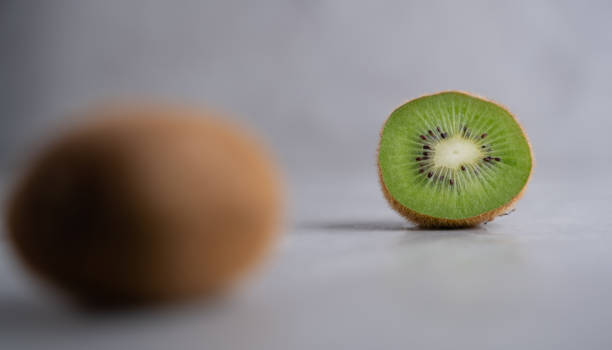 istock Ripe whole kiwi fruit and half kiwi fruit, half kiwi focused. 1296295977