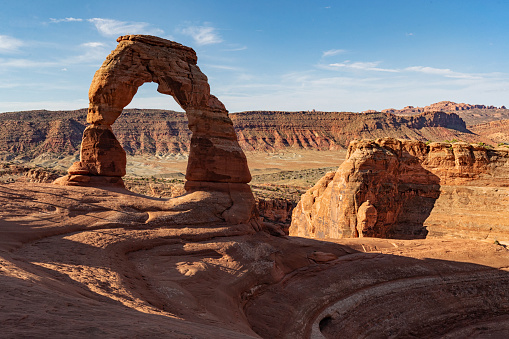 Perfect photo of Delicate Arch, Arches National Park with sun shining in the sky.