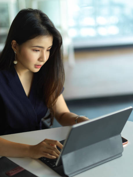 istock Female office worker focusing on her work with digital tablet in office room 1296298309