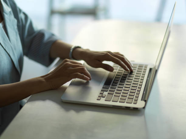 istock Female hands typing on laptop keyboard on the table in office room 1296298312