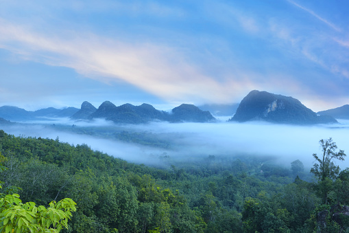 Sunrise dawn time of mountain landscape with fog on sky and clouds background in Phatthalung province, Thailand