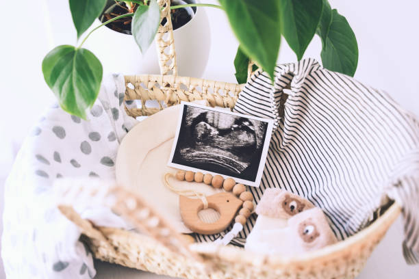 cesta de mimbre con imágenes de ultrasonido y cosas para el bebé recién nacido - ropa, juguete de dentídito de madera, manta de algodón. - wicker basket store gift shop fotografías e imágenes de stock