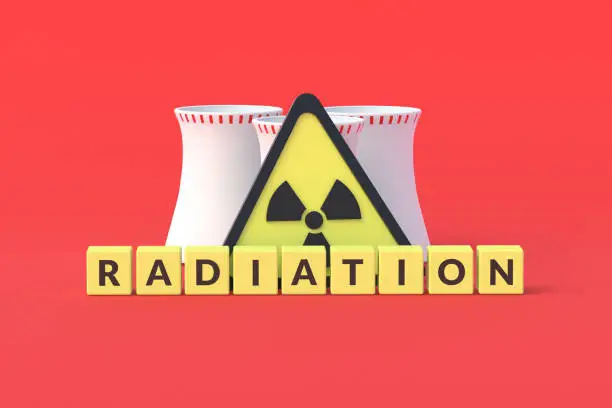 Photo of Cubes with word radiation near sign of toxic hazard and nuclear power plant on red background. 3d rendering