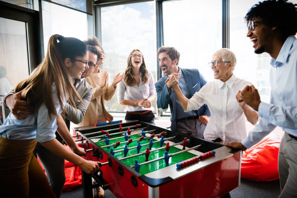 istock Colleagues playing table football in the break. 1296303478