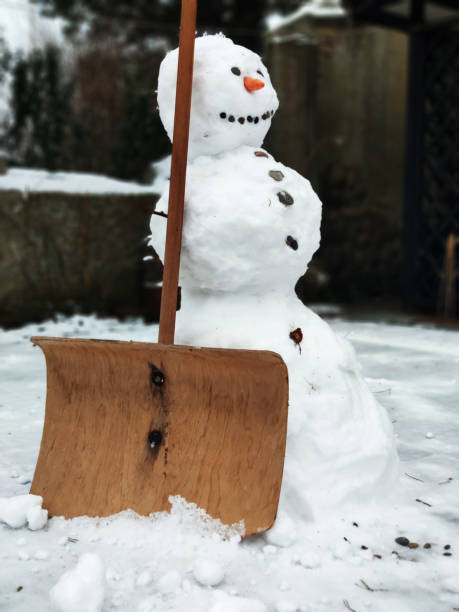 istock Snowman clearing the road 1296304536