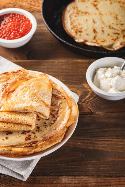 istock Stack of russian pancakes blini with red caviar, fresh sour cream 1296304699