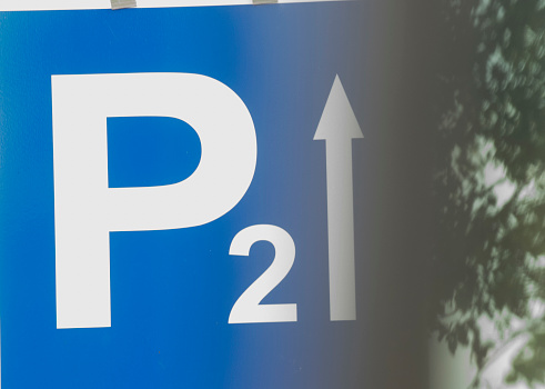 blue parking lot road sign with a white P letter