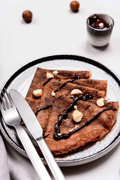 istock Chocolate Crepes with Chocolate Sauce served with macadamia nuts on a plate 1296307816