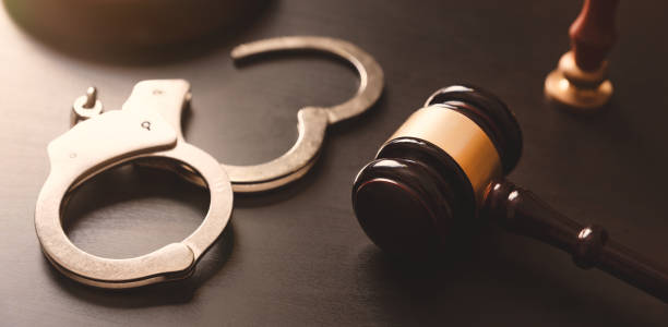 Crime and violence concept with handcuffs Handcuffs and wooden gavel. Crime and violence concept. arrest photos stock pictures, royalty-free photos & images