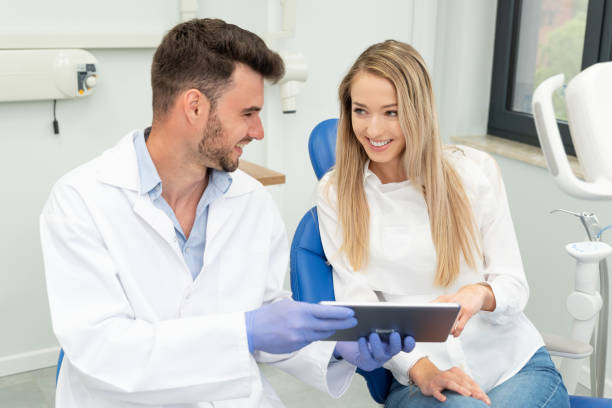 istock Dentist showing teeth x-ray on tablet screen 1296308774