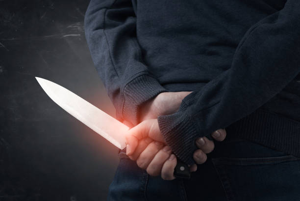 istock Murderer holding knife in his hand 1296308827