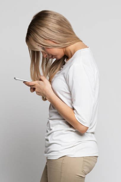 Woman using mobile phone with scoliosis, side view. Rachiocampsis, kyphosis curvature of the spine, Incorrect posture, scoliosis, orthopedics Caucasian female using mobile phone with scoliosis, side view. Rachiocampsis, kyphosis curvature of the spine, Incorrect posture, scoliosis, orthopedics concept bad posture stock pictures, royalty-free photos & images