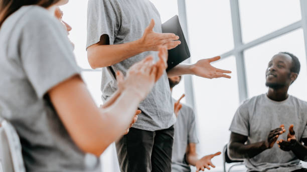 istock close up. business team sitting in a circle and applauding their speaker 1296310663