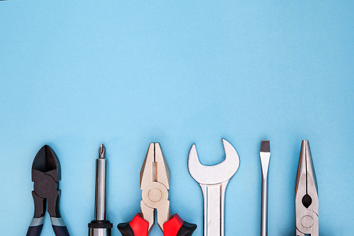Various tools worker, hammer, wrench, screwdriver, pliers on blue background, top view with free space