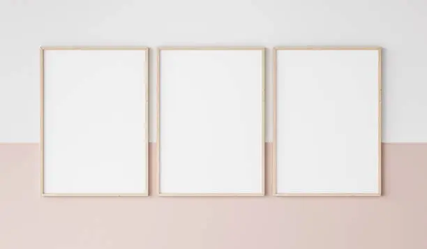 Photo of three wooden frames on pink and white wall, frame mockup