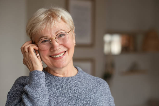 istock Senior woman smiling talking on phone at home 1296313110