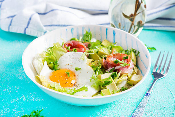 istock Ketogenic, paleo diet. Fried egg, prosciutto, avocado and fresh salad on blue table.  Keto breakfast. Brunch. 1296313635