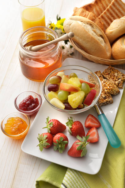 istock Breakfast: Fruit Salad, Bread Buns, Orange Juice and Honey Still Life 1296315989