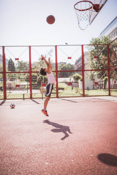 istock Young boy playing basketball outdoor 1296316091