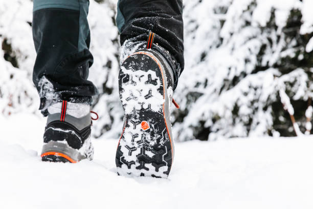 istock Hiking boot closeup, winter walking in snow. 1296316147
