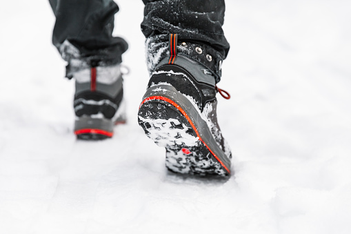 Hiking boot closeup, winter walking in snow.