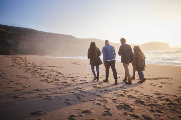 istock Group of teens walking on the beach at sunset 1296316904