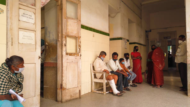 Patients are  seen waiting to get dressing up for their injuries outside the Dressing ward at the rural General Hospital in Mysuru,Karnataka,India. Poor Patients are  seen waiting to get dressing up for their Accidental injuries outside the Dressing ward at the rural General Hospital corridor in Mysuru,Karnataka,India. india hospital stock pictures, royalty-free photos & images