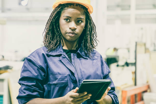 istock Content female plant worker standing with tablet and looking 1296317648