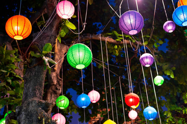 istock A brightly colored paper lantern hung under a big tree at night. 1296317960