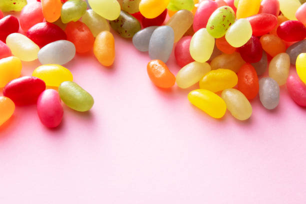 assorted bean candies placed in the corner of white background